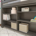 Gray wood bookshelf with woven baskets, pastel children's books, pink storage boxes and vintage radio — kids' room organizer
