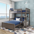 Modern wooden loft bunk bed with ladder and blue bedding in a bright kids bedroom with paneled light-blue wall, geometric rug and large window city view