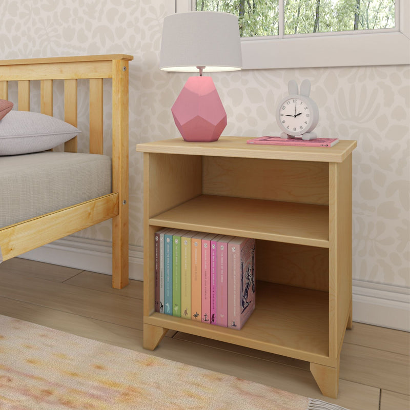 Wooden bedside table with books and a pink lamp in a cozy bedroom setting.
