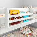White wooden kids bunk bed with built-in book pocket holding colorful children's books and checkered bedding