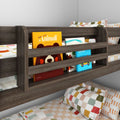 Modern dark-wood kids bunk bed with built-in slatted bookshelf storing colorful children's books, checkered pillows and patterned bedding