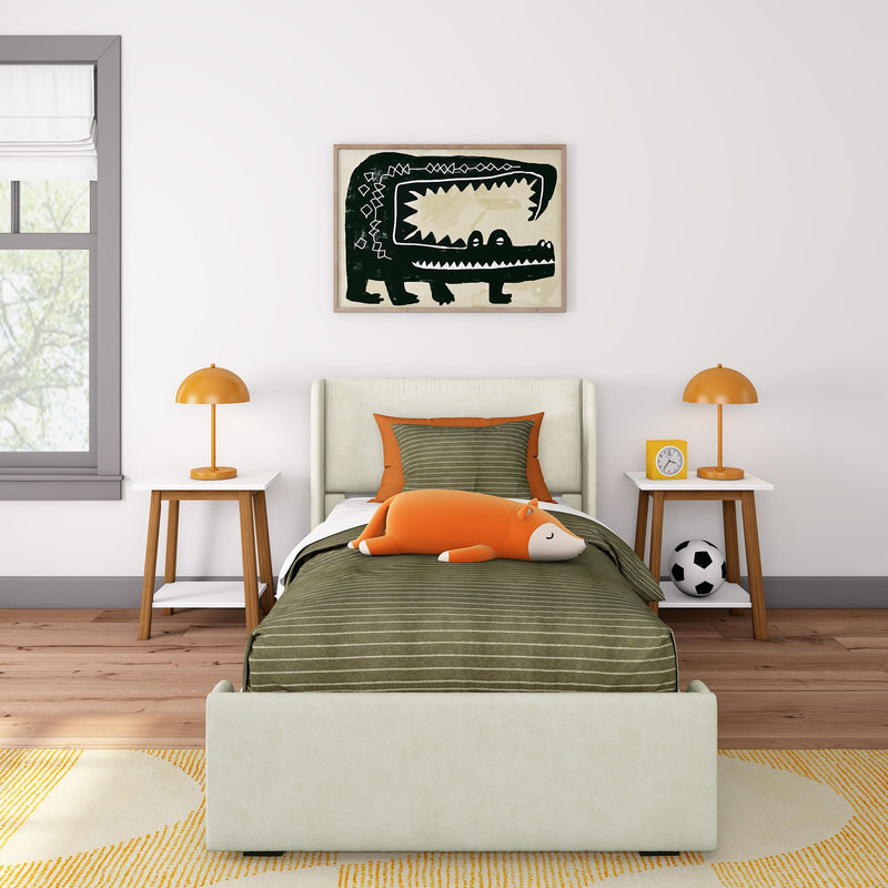 Kids bedroom with green striped bedding, orange fox plush toy, wooden nightstands with orange table lamps and clock, framed crocodile wall art and soccer ball
