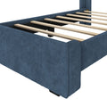 Blue upholstered platform bed frame with exposed wooden slats and center support, modern fabric-covered base
