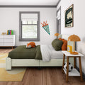 Kids bedroom interior with green striped bedding, fox plush toy, orange bedside lamps, personalized "Oliver" pennant, dinosaur wall art, white dresser with colorful books and toy airplane and soccer ball