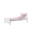 White wooden twin bed with pink fitted sheet, textured pink throw and matching pink pillows on white background