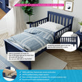 Navy blue toddler bed with removable guardrail and blue geometric duvet in a modern kids' bedroom, highlighting easy-install safety bedrail, solid wood construction and mattress support