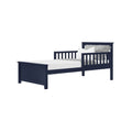 Navy blue wooden twin toddler bed with slatted guardrail, gray textured bedding and white pillow