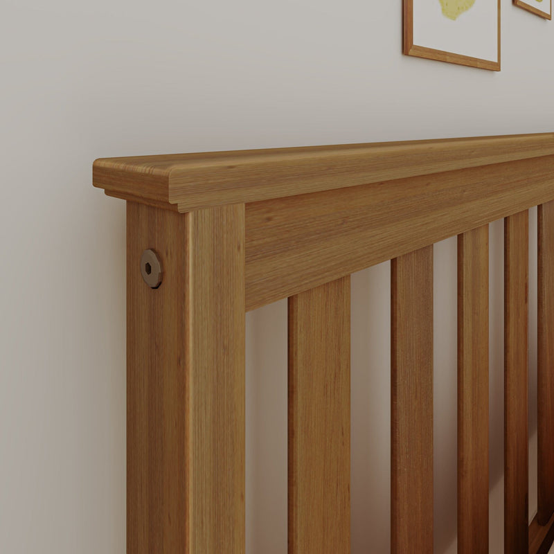 Close-up solid oak bed headboard with slatted design and natural wood grain against a white wall