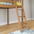 Modern wooden loft bed with angled ladder, yellow bedding and blue patterned throw over hardwood floor and striped area rug