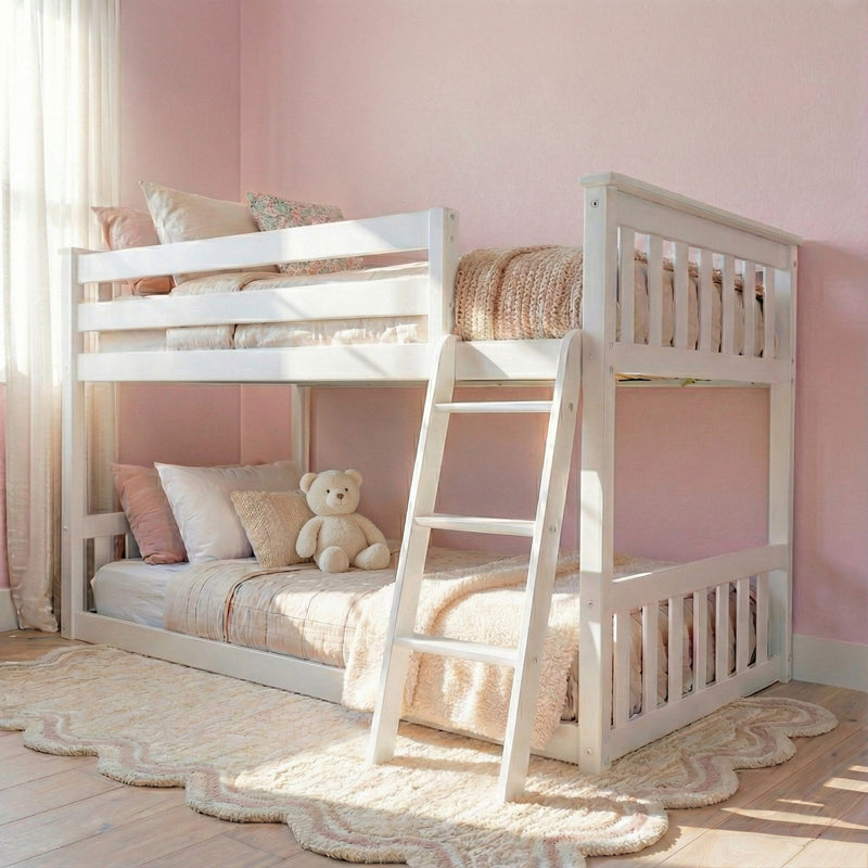 Pink nursery with white twin-over-twin bunk bed, ladder, plush teddy, knitted throw and sheer curtains — cozy kids bedroom decor