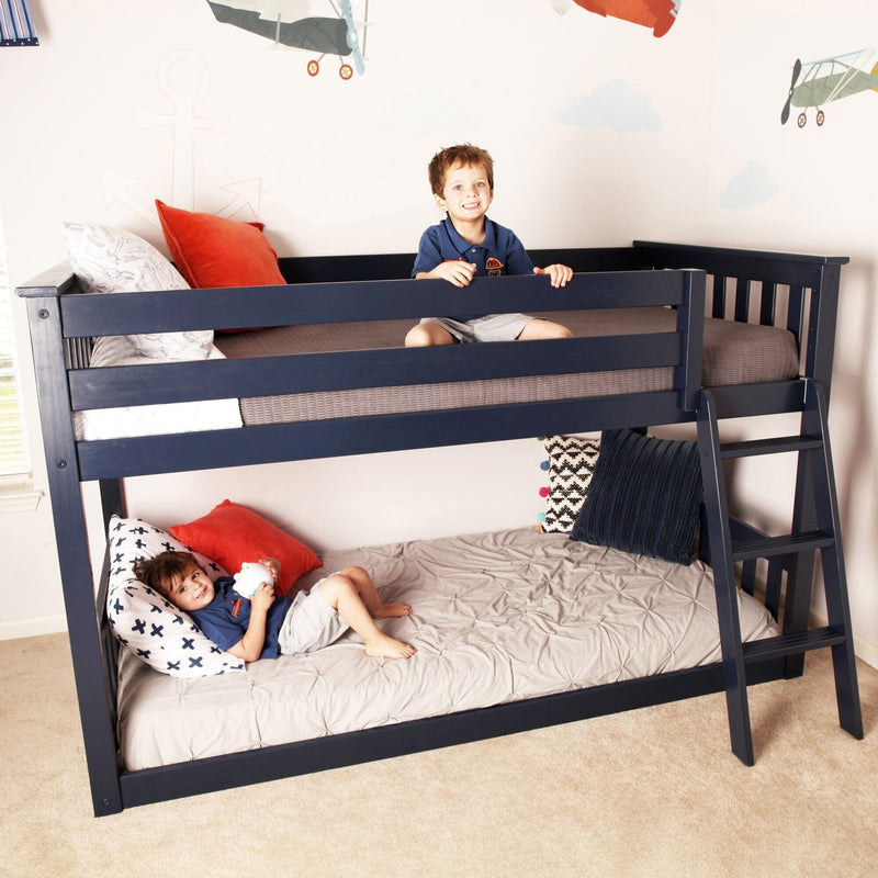 Two smiling boys on a navy blue twin-over-full bunk bed in a kids' bedroom with airplane wall decals