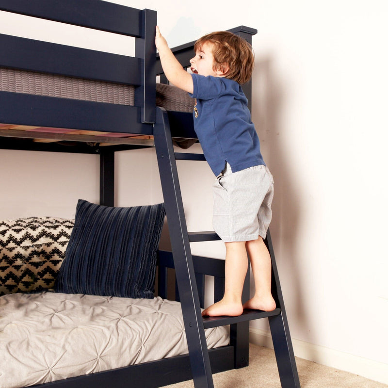 Toddler climbing navy bunk bed ladder in kids' bedroom, illustrating children's bunk bed safety and bedroom furniture