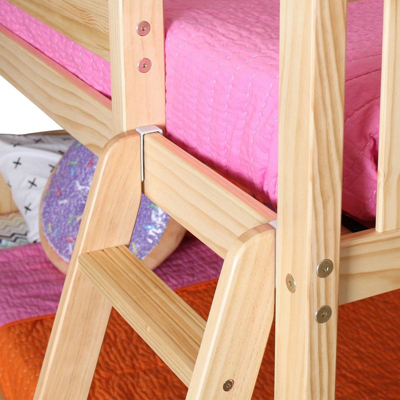 Close-up of natural pine wooden bunk bed ladder and guardrail with pink quilted mattress in a children's bedroom