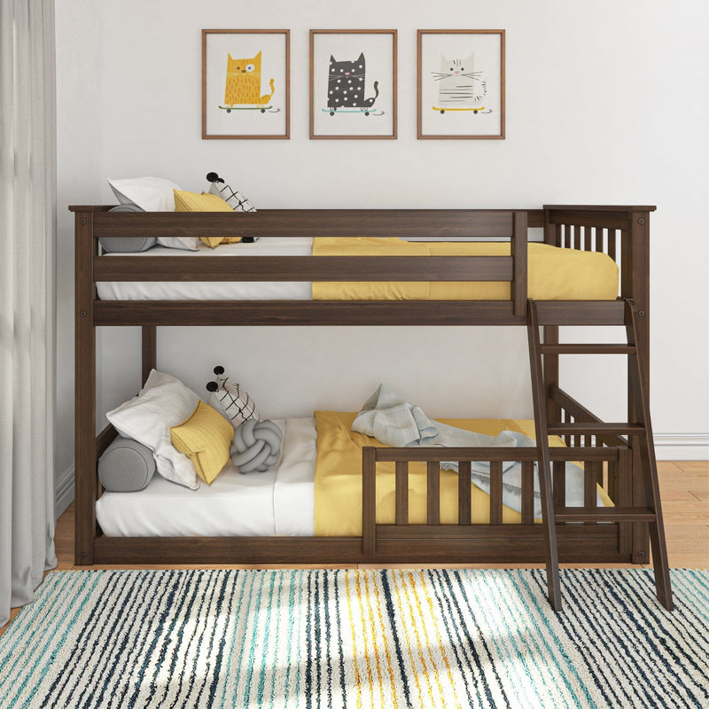 Dark wood twin-over-twin bunk bed with ladder in bright kids' bedroom, yellow bedding, playful cat wall art and striped rug