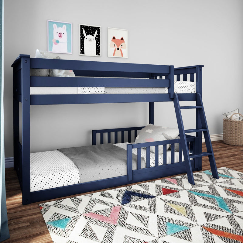 Navy blue wooden twin-over-twin bunk bed for kids with ladder in a decorated children's bedroom, polka-dot bedding, colorful geometric rug and framed animal wall art