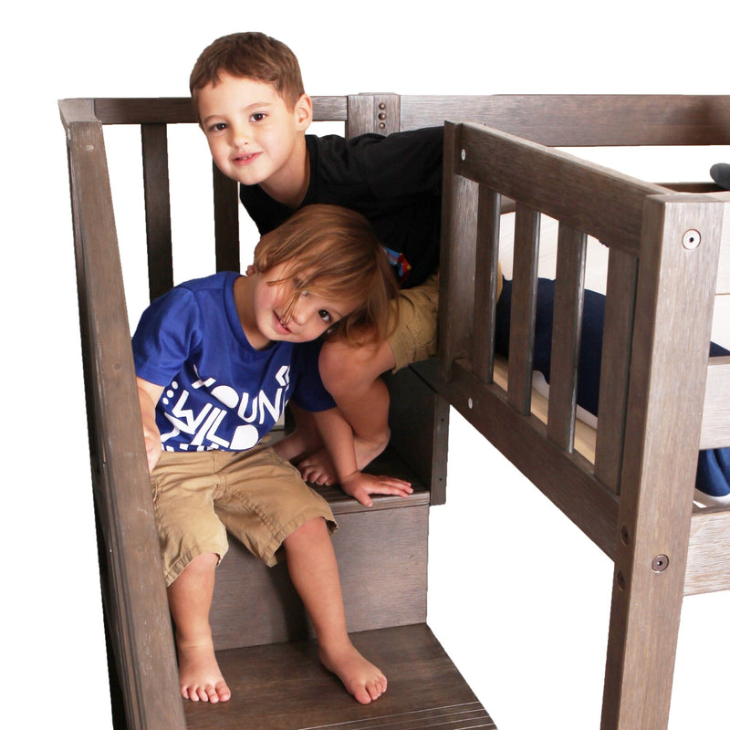 Two young boys on built-in stairs of a gray wooden loft bunk bed with guardrail, kids' bedroom furniture