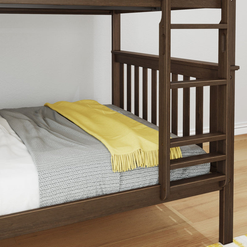 Close-up of dark wood bunk bed ladder and rails with gray knit blanket and yellow throw on mattress in a modern bedroom interior