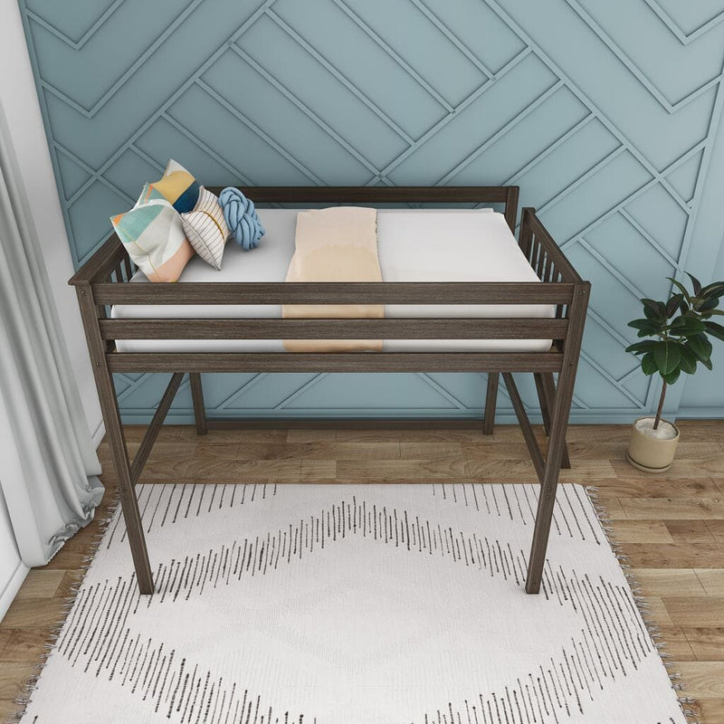 Modern wooden toddler loft bed with safety rails, white mattress and colorful pillows in a stylish blue nursery with geometric accent wall, rug and potted plant