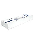 White low-profile under-bed storage drawers (trundle) with navy-striped blanket and decorative pillow, wooden space-saving underbed organizer for bedroom and kids' storage