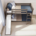 Modern gray wooden bunk bed with slide and ladder, navy and beige bedding and pillows in a cozy space-saving kids' bedroom
