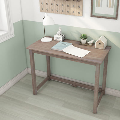 Minimal home office with wooden desk, white desk lamp, succulent, decorative birdhouse and notebook against a mint green half-painted wall
