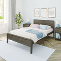Modern cozy bedroom interior with gray wood bed frame, white quilt and pastel pillows, blue throw, matching nightstands and lamps, framed wall art, potted plant and natural window light