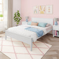 Pastel kids bedroom with pink scallop wallpaper, white bed, blue and blush pillows, bedside tables and lamps, potted plant and rainbow wall art — modern nursery decor ideas