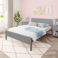 Pastel pink bedroom with gray bed frame, white quilted bedding, blue throw pillows, pink patterned wallpaper, rainbow wall art and plush pink diamond rug