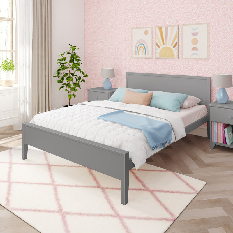 Pastel pink bedroom with gray bed frame, white quilted bedding, blue throw pillows, pink patterned wallpaper, rainbow wall art and plush pink diamond rug