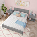 Girls bedroom with pink scallop wallpaper, gray bedframe, pastel pillows, matching nightstands, lamps and framed rainbow art