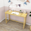 Minimalist natural light wood writing desk for a small home office or kids' room against a pastel pink wall, styled with a table lamp, alarm clock, open book, succulent and decorative birdhouse on a wood floor
