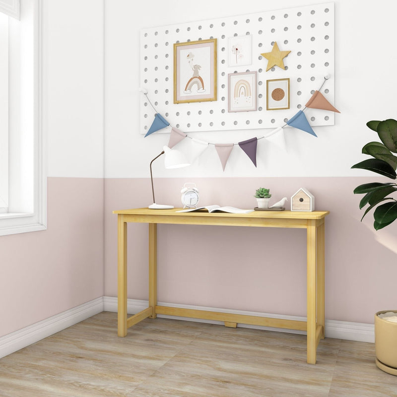 Small wooden desk in pastel pink kids' room with pegboard wall decor, colorful bunting garland, white desk lamp, alarm clock and succulent plant