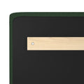 Close-up of green bouclé upholstered headboard corner with black backing and light wood support bracket secured by a metal screw