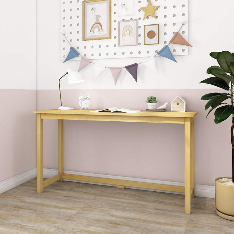 Minimalist light wood desk against a pastel pink-and-white wall in a children's room, styled with colorful bunting and framed rainbow prints, white desk lamp, alarm clock, open book, small succulent and birdhouse for modern nursery or home office decor