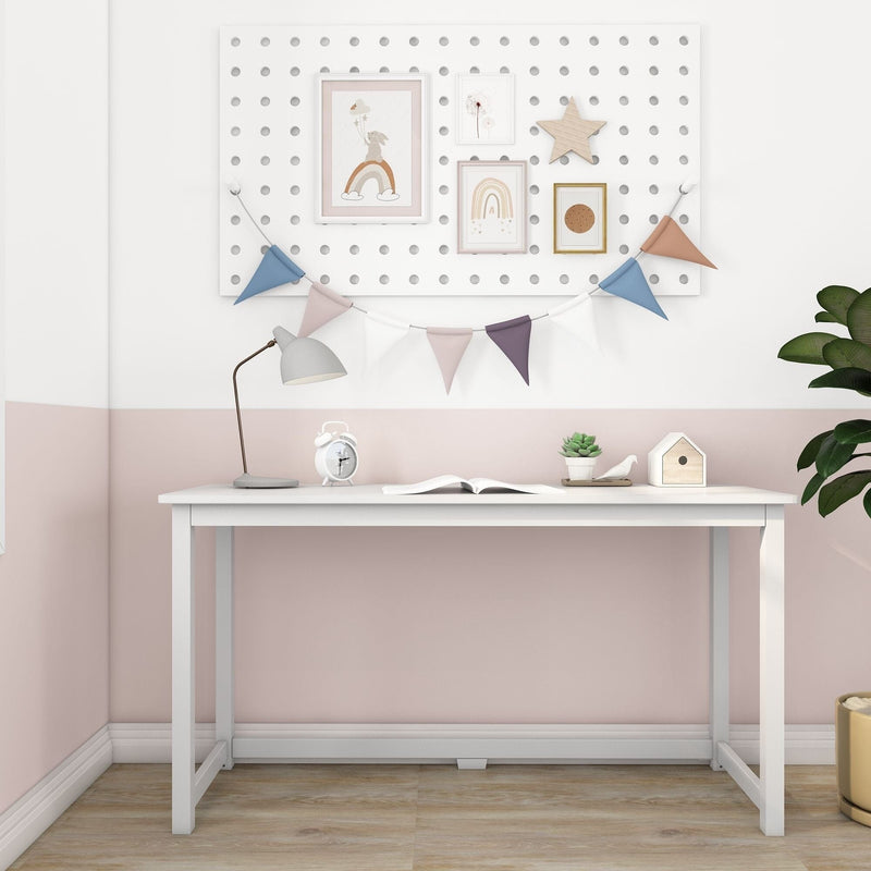 White kids study desk in a pastel pink nursery with pegboard gallery wall, bunting, desk lamp, alarm clock, succulent and birdhouse — modern minimalist children's room decor