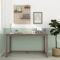 Minimal wooden desk in pastel mint nursery, featuring pegboard shelves with decor, white desk lamp, potted plant, rainbow wall art and stationery organizer