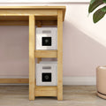 Light wood shelving unit holding two white storage bins with black chalkboard label panels against a pastel pink wall, minimalist home storage and nursery organization