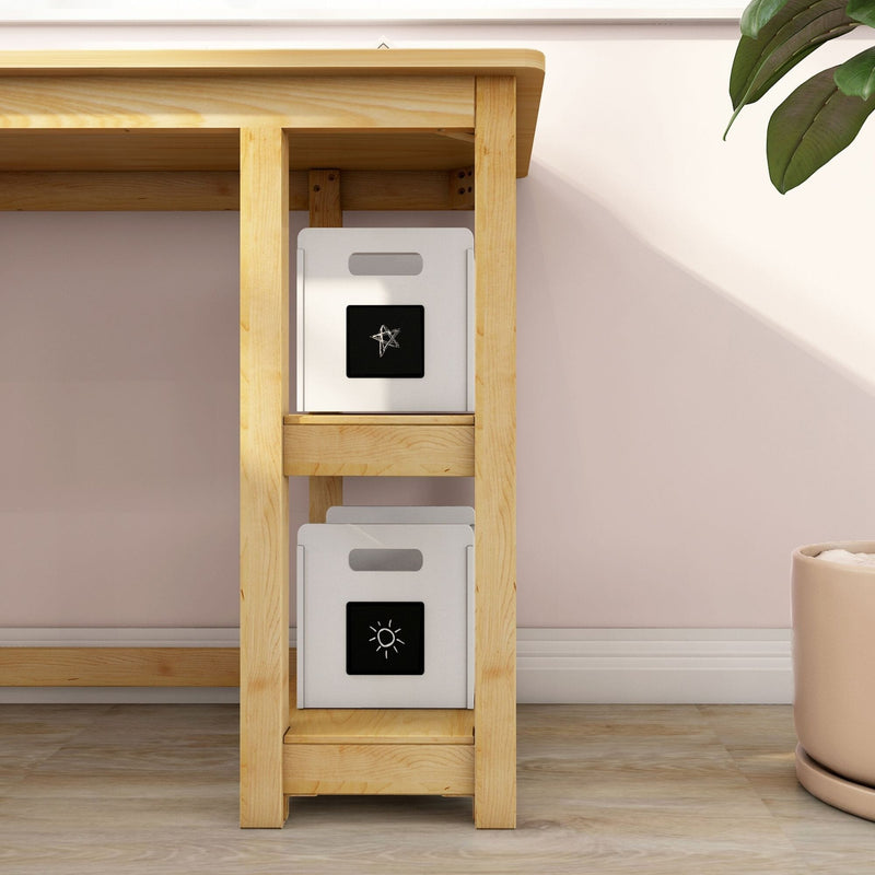 Light wood shelving unit holding two white storage bins with black chalkboard label panels against a pastel pink wall, minimalist home storage and nursery organization