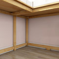 Corner view of light pine loft bed frame supports and joists over hardwood floor against a pink bedroom wall