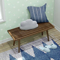 Cozy entryway with modern wooden bench, striped cushion, cloud-shaped pillow, and blue slippers.