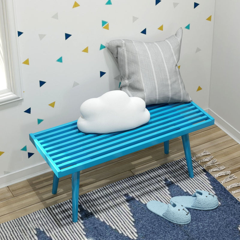 Modern children's room with blue bench, cloud pillow, cozy slippers, and geometric wall decor.