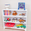 White playroom bookshelf filled with children's toys and games: Connect Four, colorful board games, stuffed sloth, toy dinosaurs, wooden airplane and toy trucks.