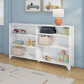 White cubby bookshelf in a pastel blue children's room with toy storage, featuring a red vintage toy car, wooden airplane, fabric storage bins, alphabet blocks, an orange table lamp and framed race car prints
