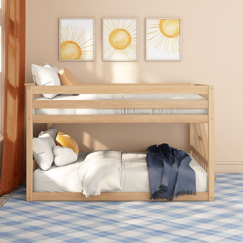 Wooden bunk bed in a neutral kids bedroom with sun wall art, cozy white bedding, yellow accent pillows and a blue throw on a patterned rug