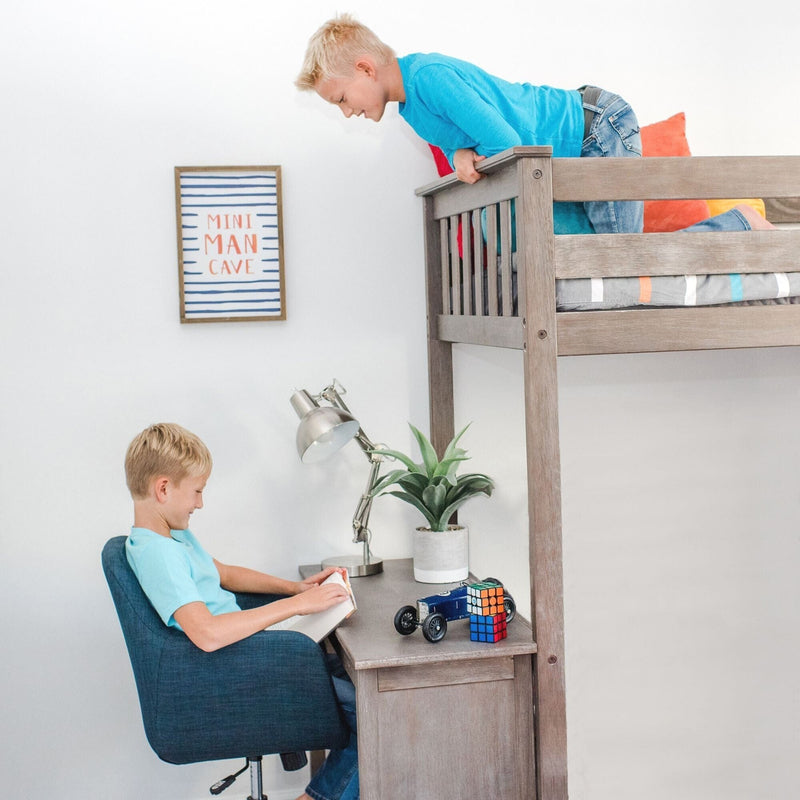 Kids loft bed with desk study area: boy reading at desk under bunk while another leans from top bunk, toy car, Rubik's Cube and "Mini Man Cave" sign