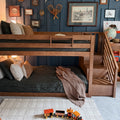 Cozy kids' bedroom with wooden bunk bed, navy paneled accent wall, vintage framed art, globe and wooden toy train on cream rug