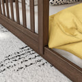 Solid wood bed frame with vertical slats, yellow duvet and white mattress, black-and-white throw pillow and textured area rug, close-up