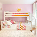Pink kids' bunk bed room with pastel quilt, checkered blanket, unicorn plush and Flower Babe wall art