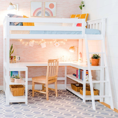 White loft bed with built-in desk and ladder, pastel rainbow wall art, string lights, wooden chair, potted plants and woven baskets in a bright modern kids' bedroom