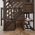 Dark brown wooden staircase railing with diagonal balusters and built-in under-stairs storage shelves holding blue sneakers and stacked magazines in a modern rustic entryway